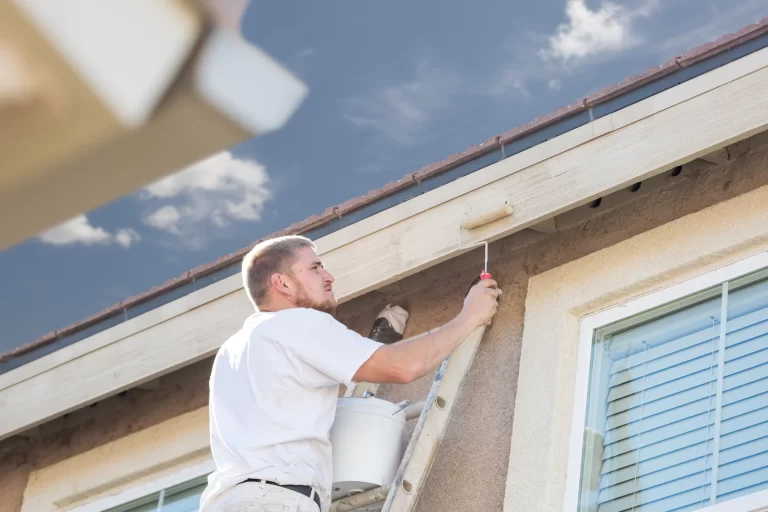 professional-painter-using-a-small-roller-to-paint-house-fascia-.webp